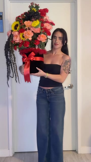 HeirBloom founder with a bright sunflower and lily bouquet